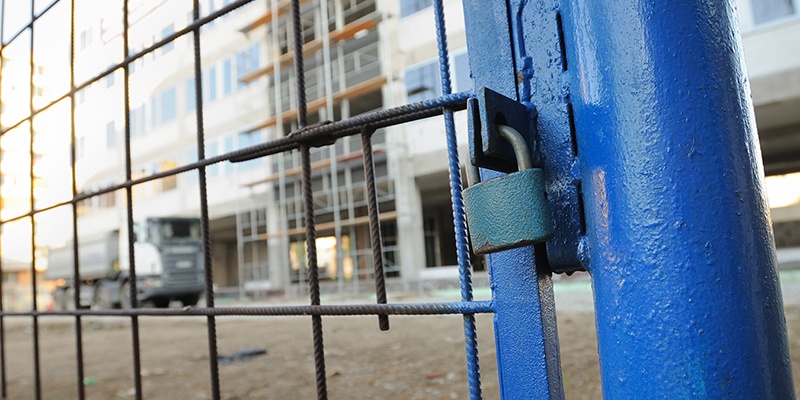 Construction site with blue gate and padlock