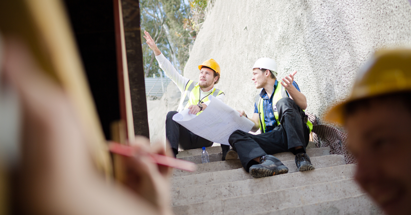 Construction professionals reviewing project plans at a job site.