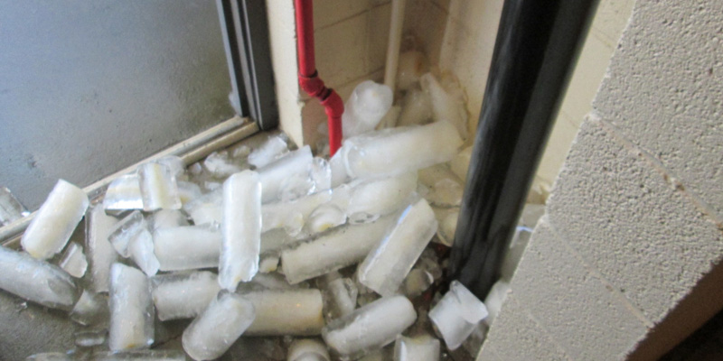 Apartment stairway with frozen pipes and ice