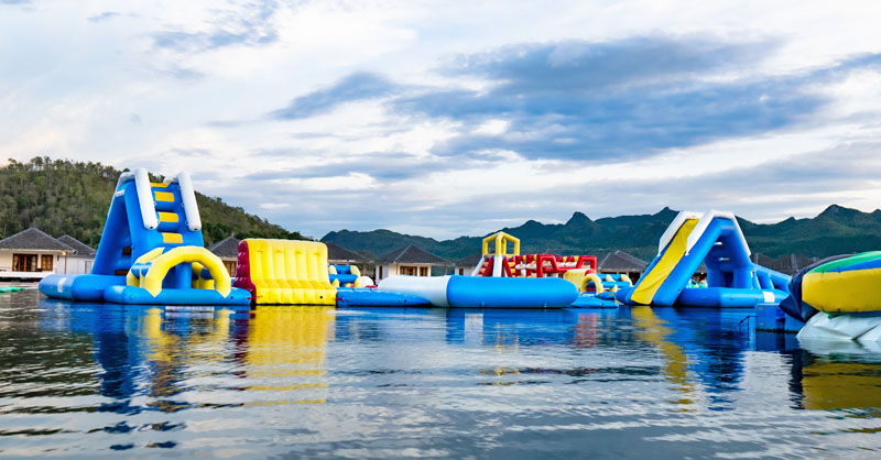 Inflatable slides floating on lake near dock