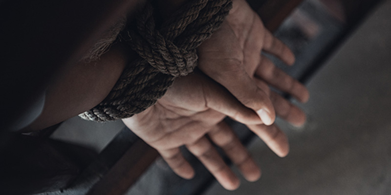 hands tied with rope to chair