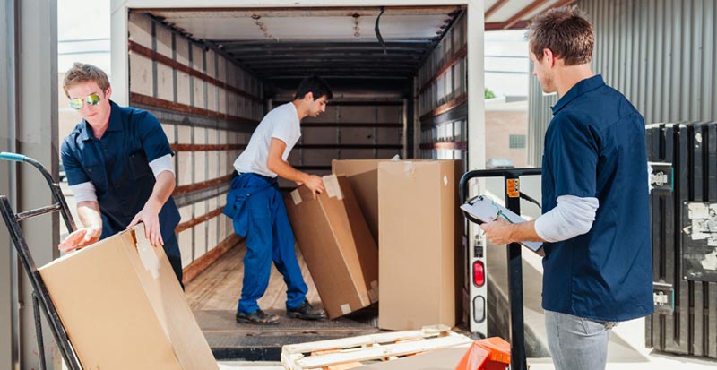 Three male workers unloading a delivery truck